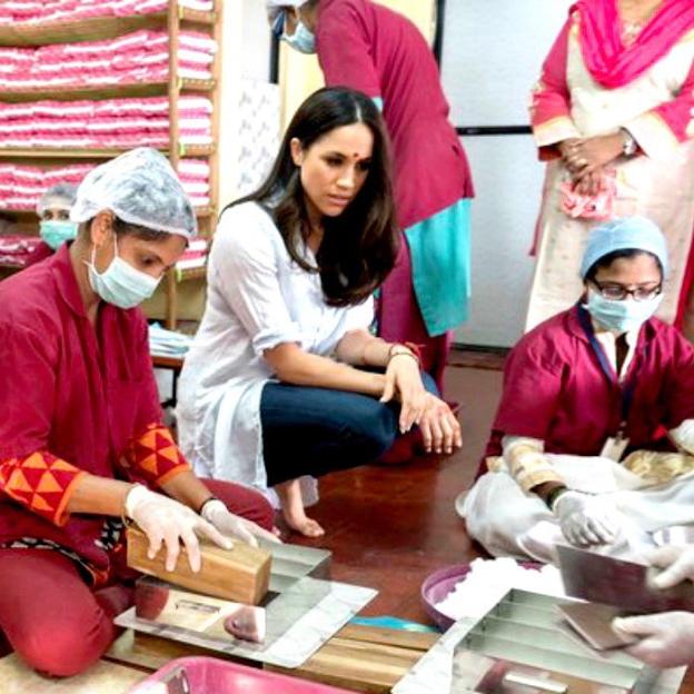 Meghan Markle observing women making sanitary napkins.