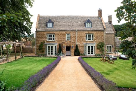 Stone farmhouse with lavender lined pathway and bicycles.