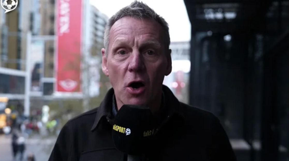 Man speaking into a microphone outdoors.