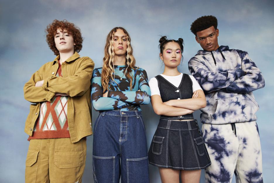 Four teenagers standing with arms crossed.