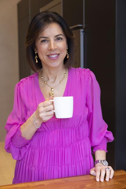 Woman in pink dress holding a mug.