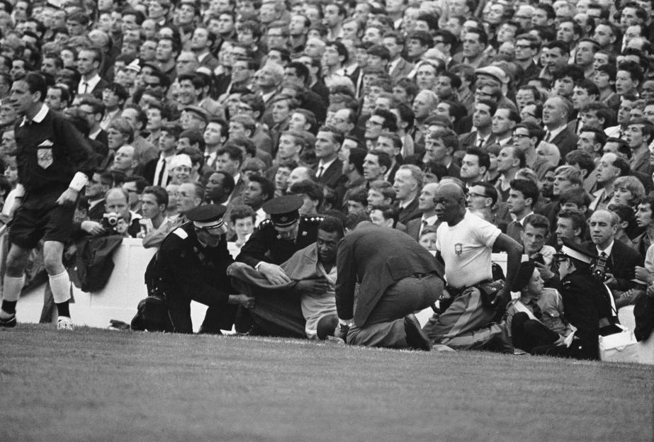 Injured PelÃ© being attended to by medical personnel on the field.