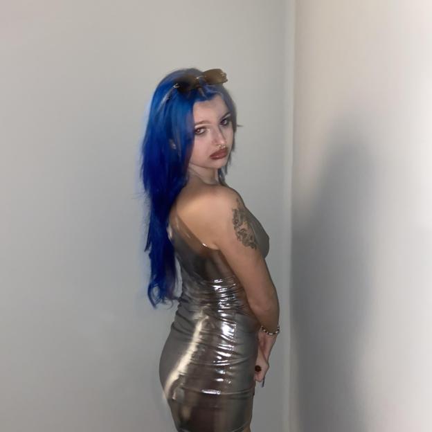 Woman with blue hair wearing a silver dress.