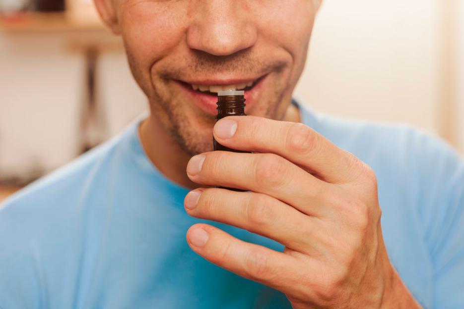 Man smelling essential oil from a small bottle.