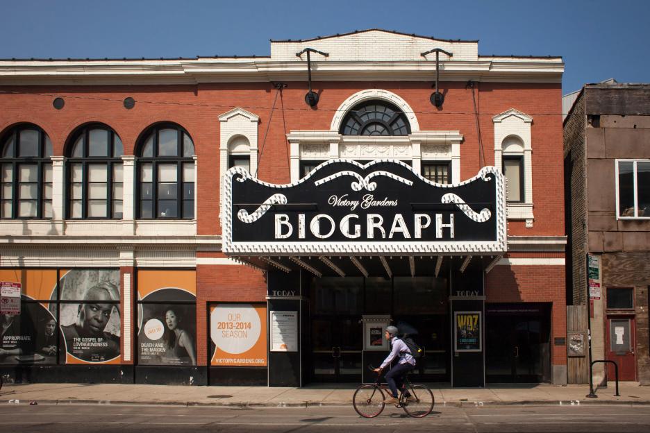 Cyclist passing the Victory Gardens Biograph Theater in Chicago.