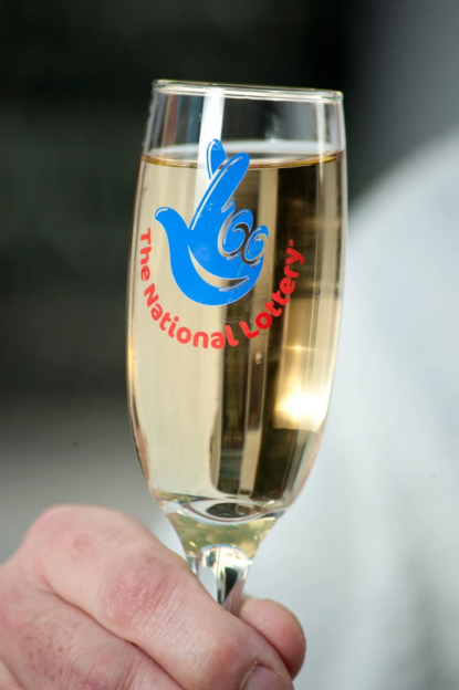 a glass with the national lottery logo on it