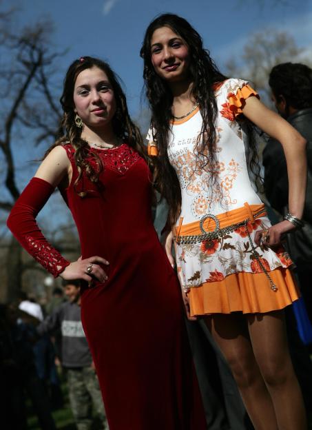 Two Romani girls in dresses wait to be chosen as brides.