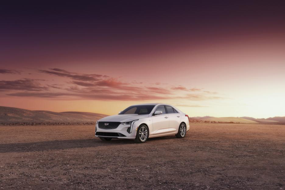 White Cadillac CT4 in a desert at sunset.