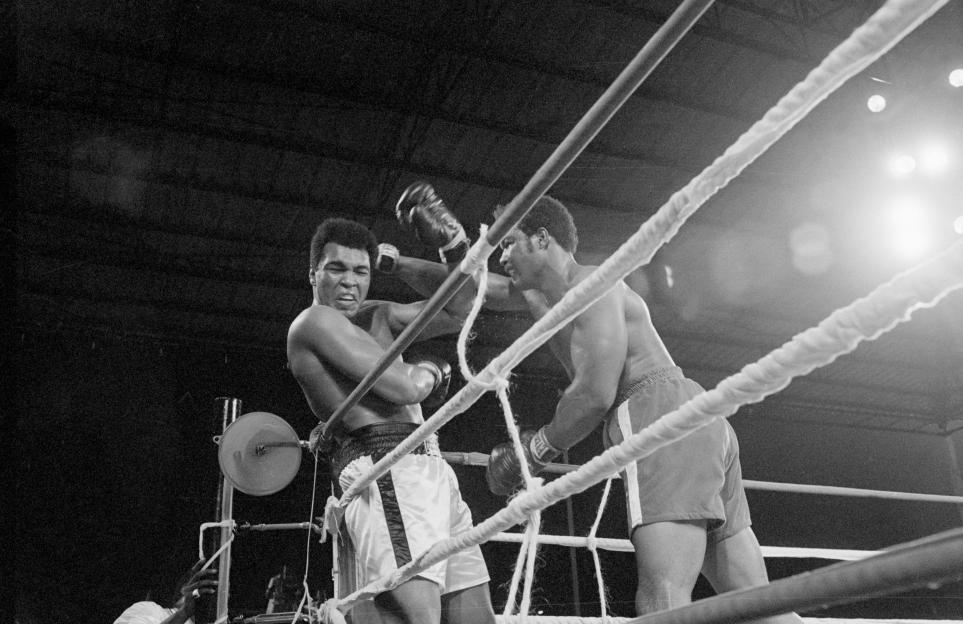 Muhammad Ali and George Foreman boxing in the ring.