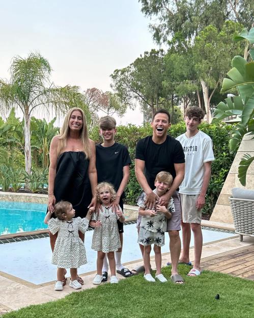 Family posing by a pool.