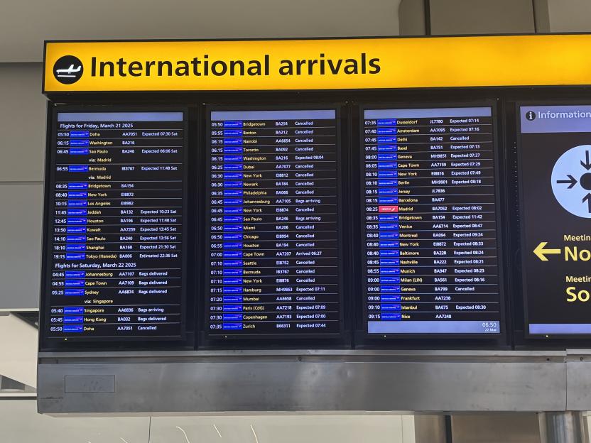 Heathrow Airport arrivals and departures board showing numerous flights, some cancelled and delayed.