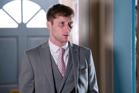 Jay Mitchell from EastEnders in a gray suit.