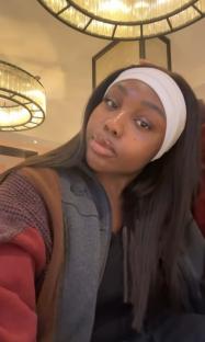 Selfie of a young woman wearing a white headband.