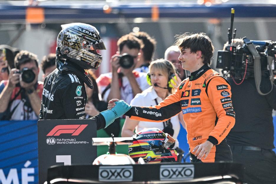 George Russell and Oscar Piastri shaking hands after a Formula 1 race.