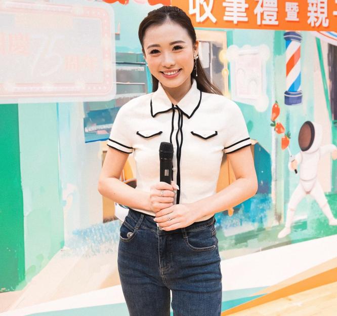 a woman stands in front of a wall with chinese writing on it