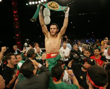 Julio Cesar Chavez Jr. celebrates a boxing victory, holding up his championship belt.