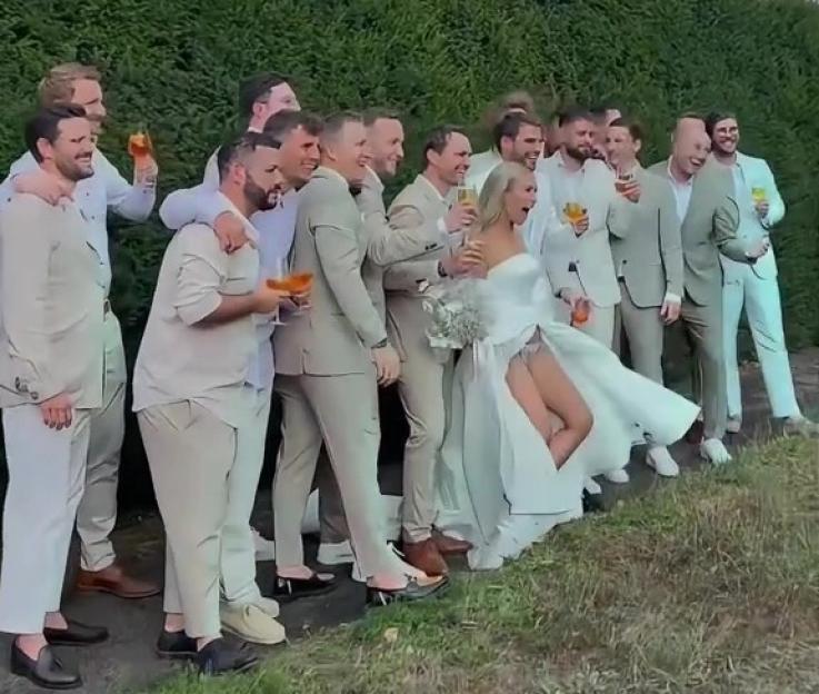 Bride flashing groomsmen at wedding.