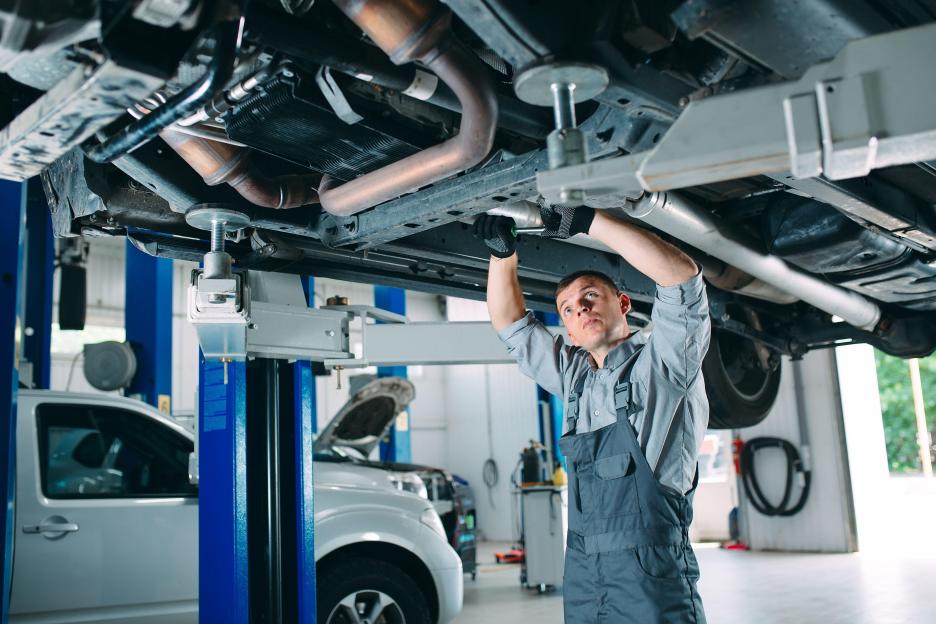 Mechanic repairing a car on a lift.