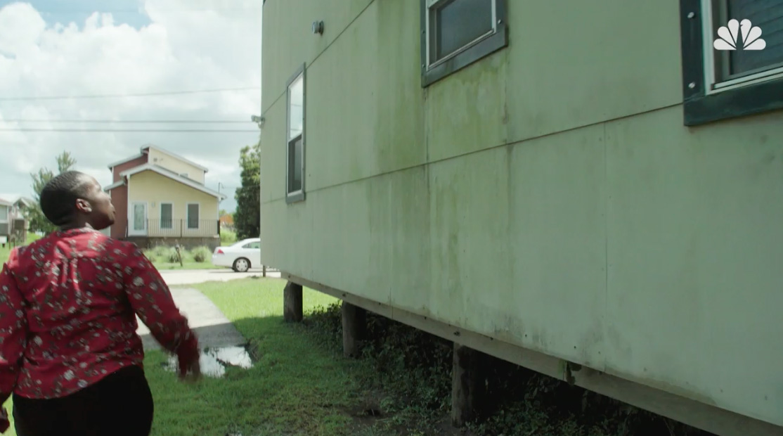 Woman walking away from a green house.