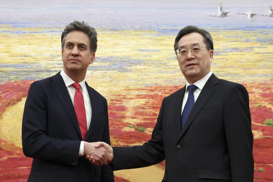 Ed Miliband and Ding Xuexiang shaking hands.