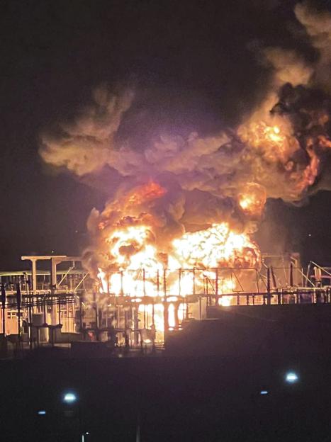 Large fire engulfing an electrical substation at night.