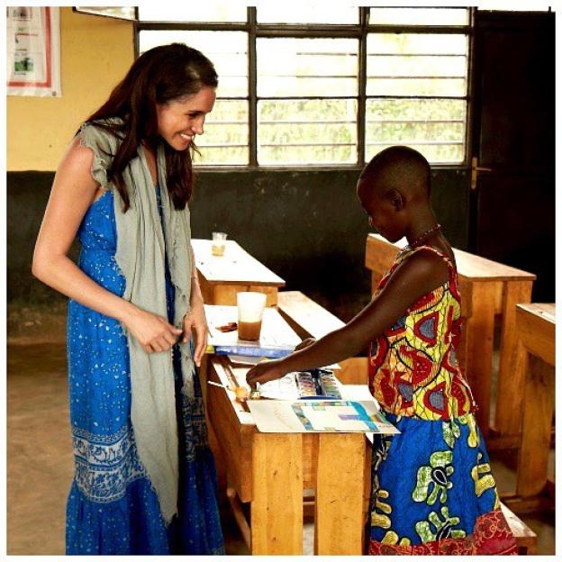 Meghan Markle working with a young girl in a classroom.