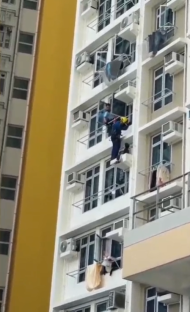 Worker rappelling down the side of a building.