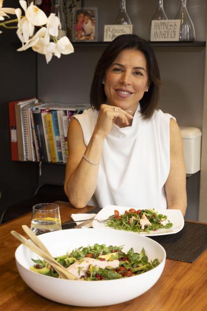 Woman at table with two bowls of salad.