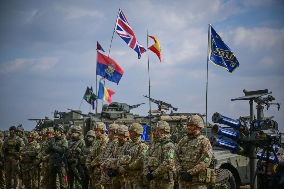 NATO military personnel standing in formation during a large-scale exercise.