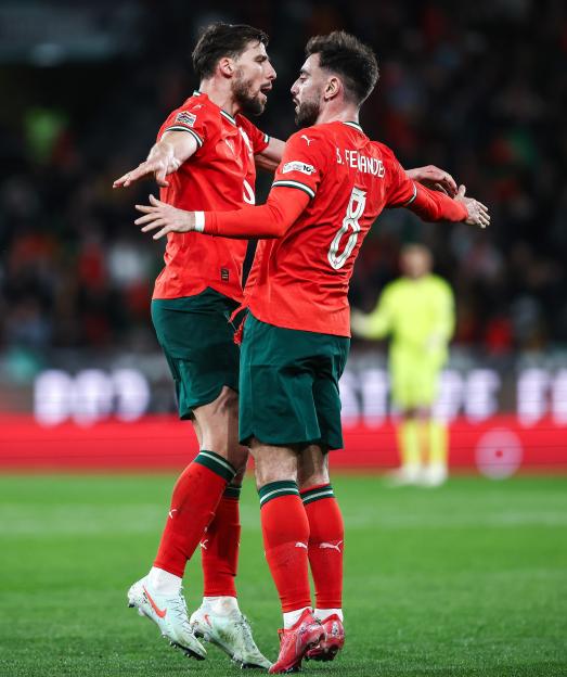 Portuguese soccer players Ruben Dias and Bruno Fernandes celebrating a goal.