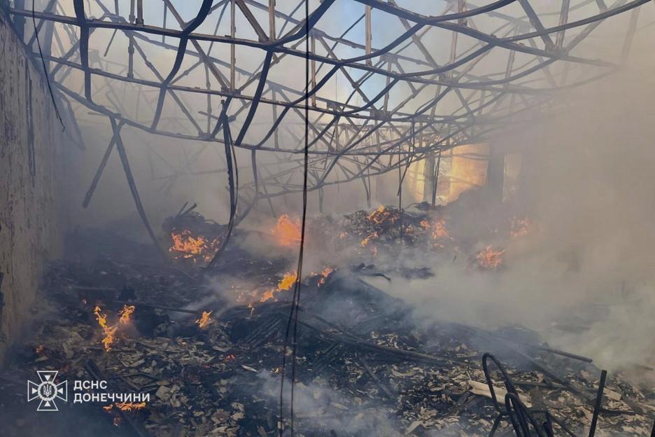 Firefighters extinguishing a fire in a damaged building.