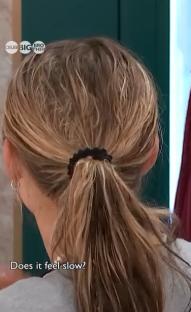 Woman's back with blonde hair in a ponytail.