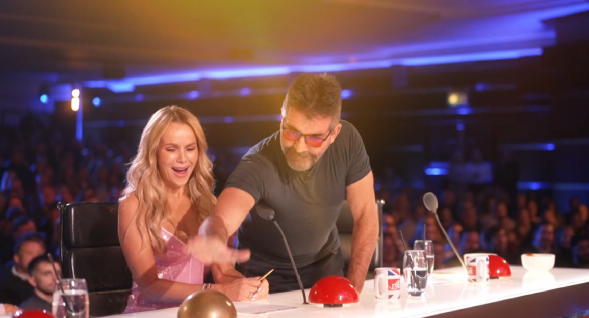 Screenshot of two judges at a talent show, laughing and interacting with a buzzer.