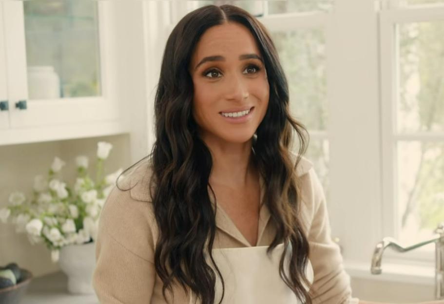 Meghan, Duchess of Sussex, in a kitchen wearing an apron.