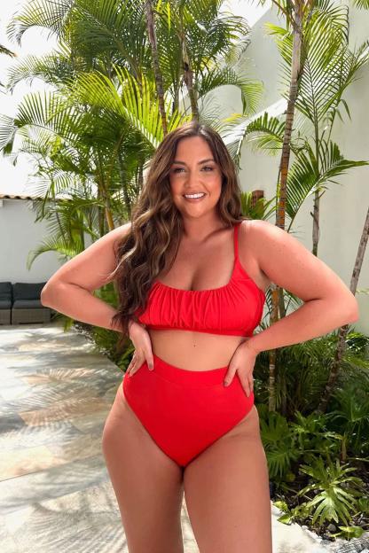 Woman in red bikini standing outdoors.