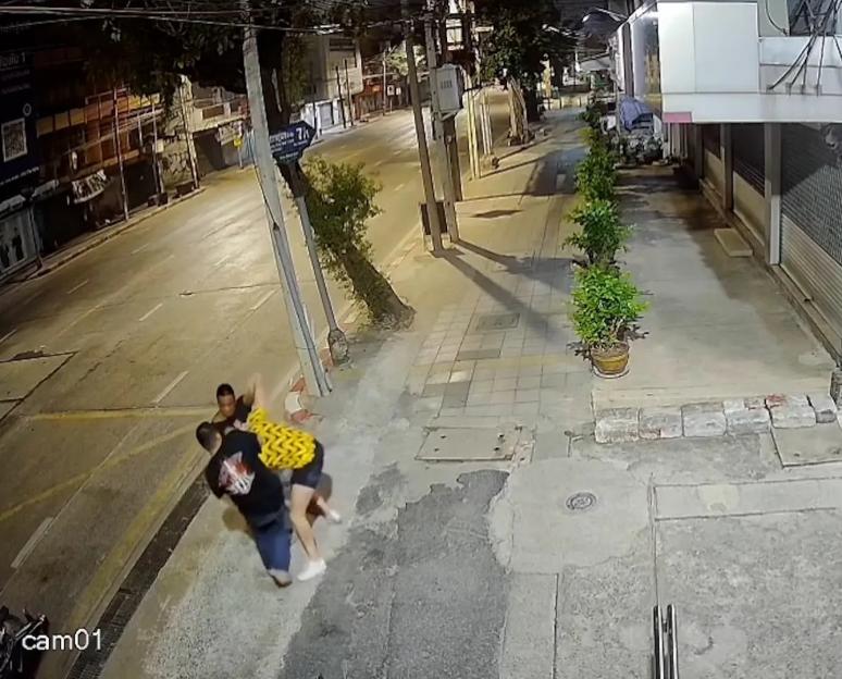 CCTV footage of a man being assaulted on a sidewalk.