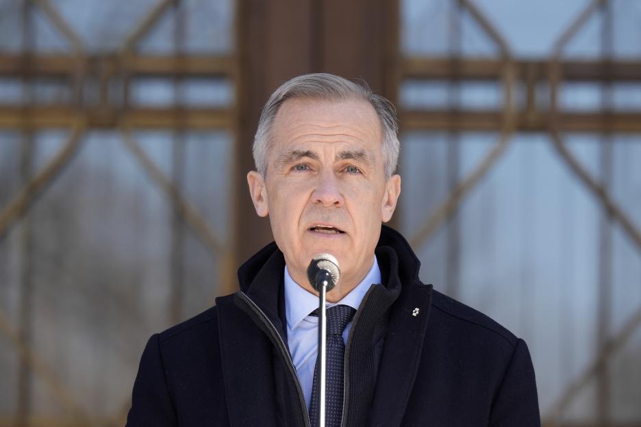 Prime Minister Mark Carney speaking at a microphone.