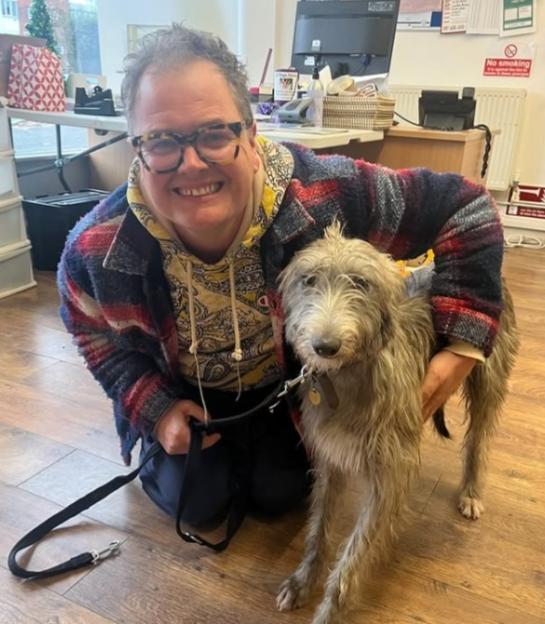 Alan Carr kneeling with his dog.