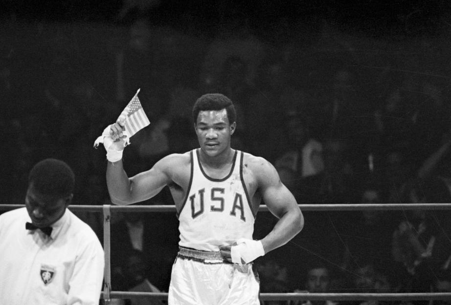 George Foreman holding an American flag after winning a boxing gold medal at the 1968 Olympics.