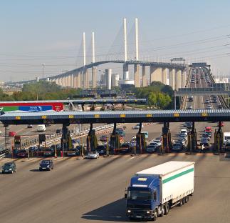 Traffic at the Dartford Crossing toll booths with the Queen Elizabeth II Bridge in the background.