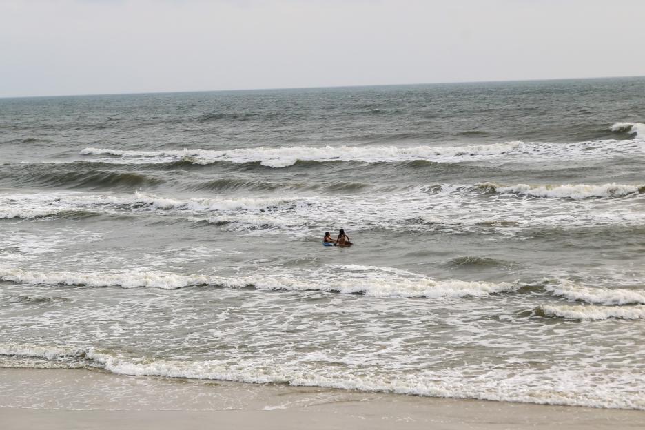 Two people boogie boarding in ocean waves.