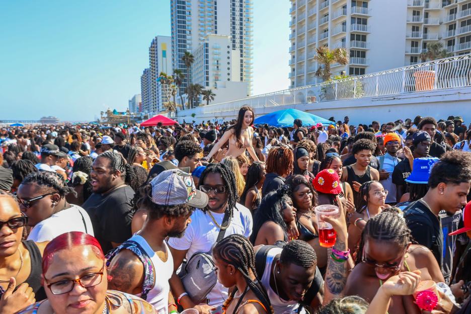 Large crowd of people partying on a beach in Daytona Beach, Florida.