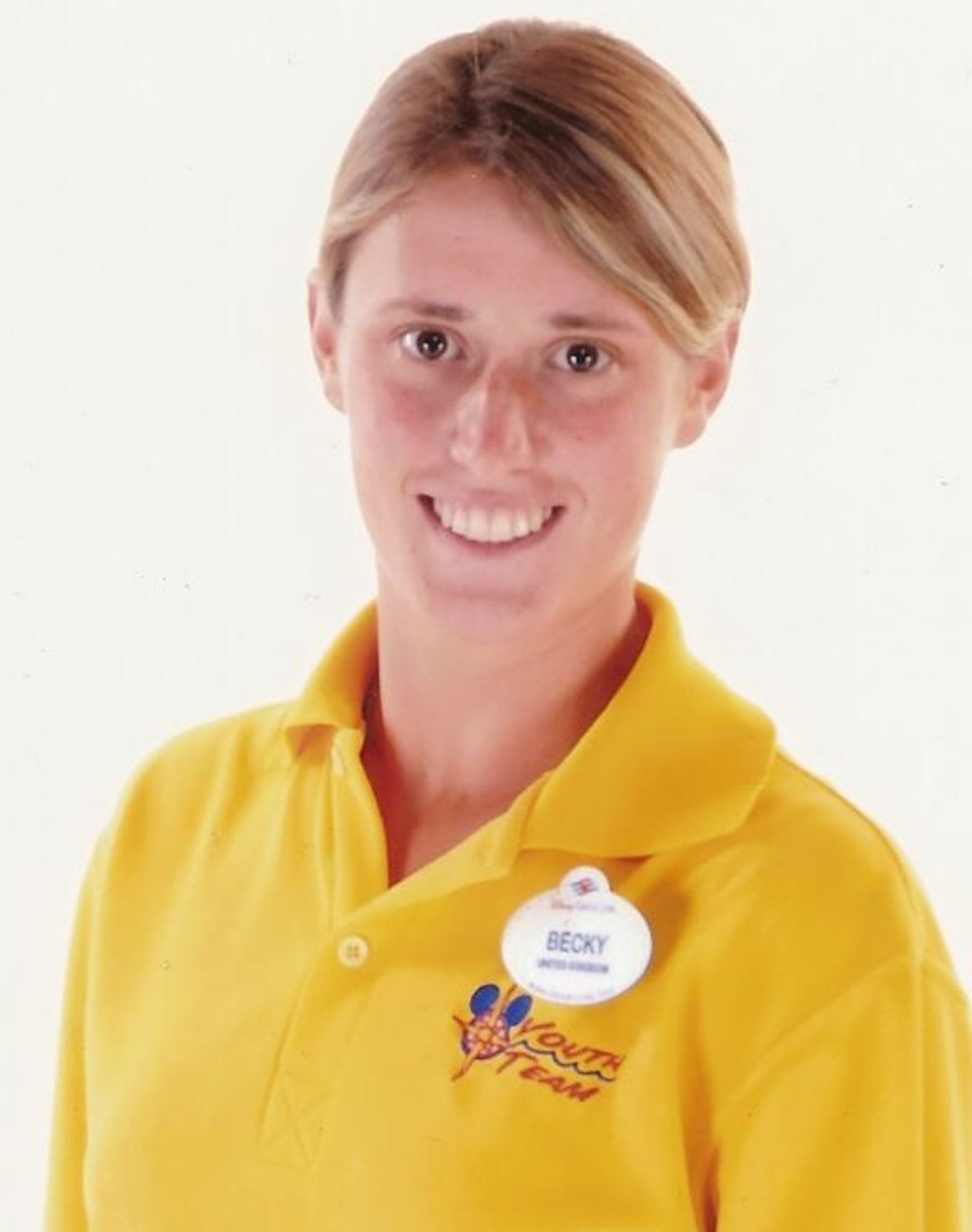 Photo of Rebecca Coriam wearing a yellow Youth Team polo shirt.