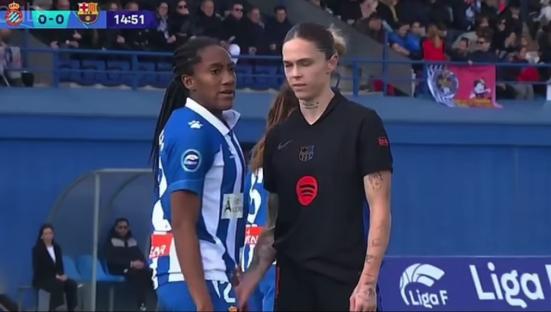 Two female soccer players facing each other on the field.