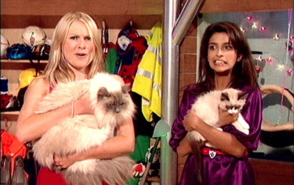 Two Blue Peter presenters apologize for a name-changing online poll, holding cats named Socks and Cookie.