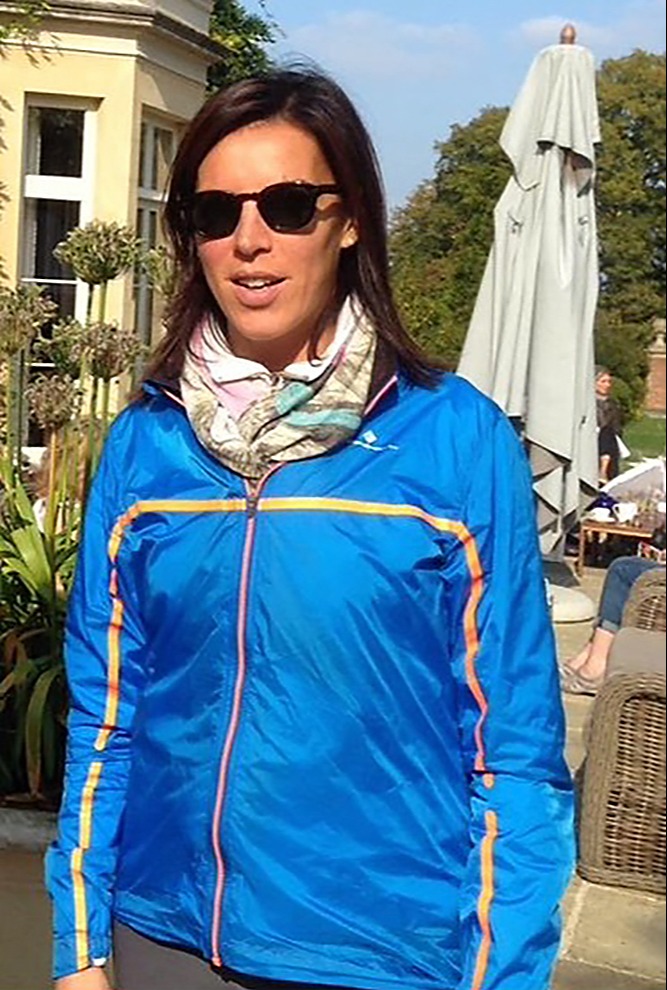 Woman in blue jacket and sunglasses.