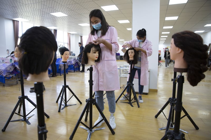 Students braid wigs during a class at in China’s far west Xinjiang region