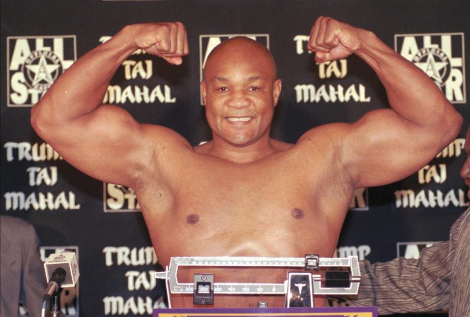 George Foreman flexing his muscles at a weigh-in.