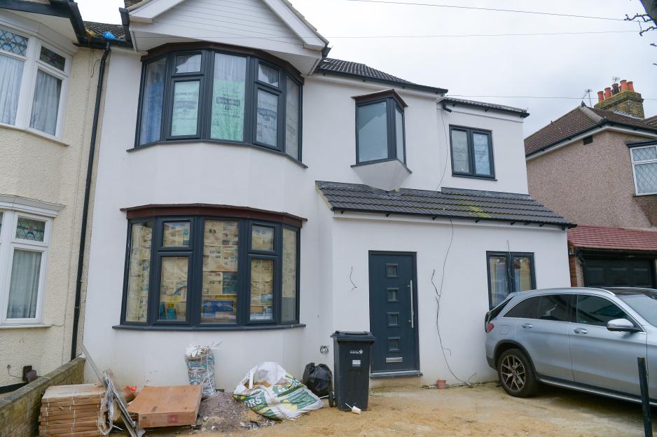 House under construction with building materials in front.