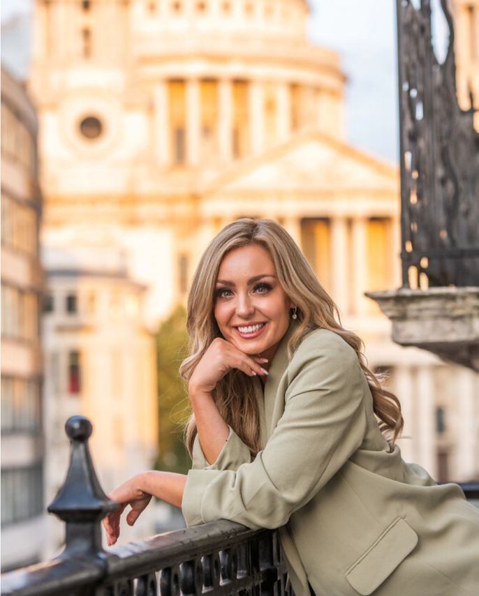 Amy Dowden leaning on a railing.